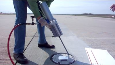 Person installing a runway light with sealant.